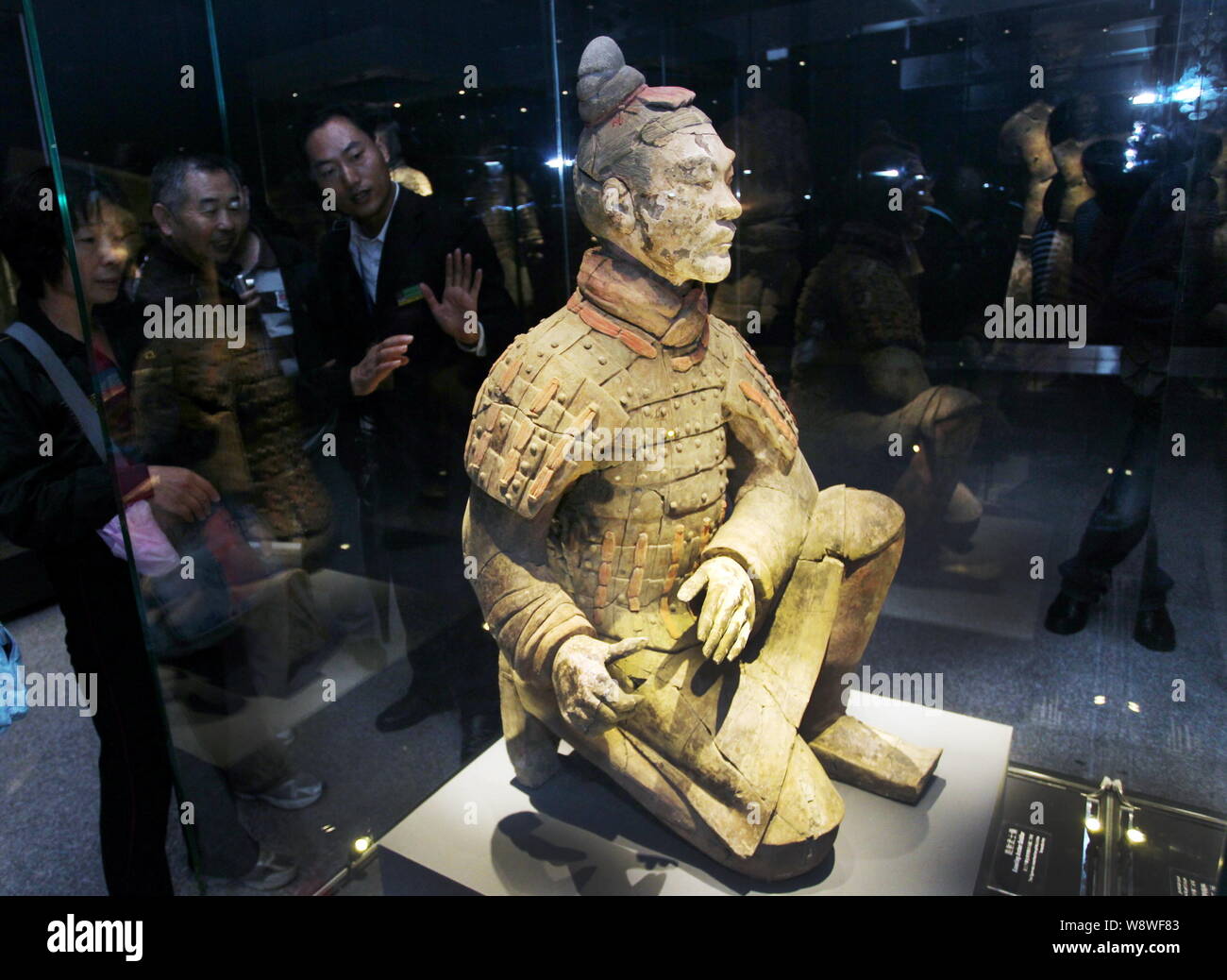 Visitors look at a colored terracotta warrior during an exhibition of colored Terracotta