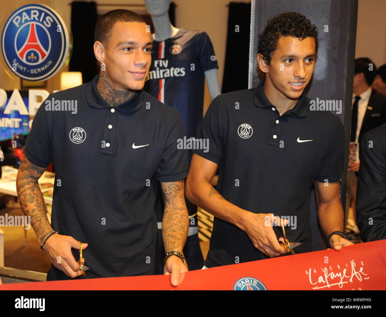 Gregory van der Wiel, left, and Marquinhos of Paris Saint-Germain football  club prepare to cut the ribbon during the opening ceremony for the Pop up S  Stock Photo - Alamy