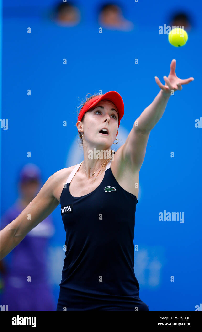Alize Cornet of France serves against Kirsten Flipkens of Belgium during the women's singles third round of the 2014 WTA Wuhan Open tennis tournament Stock Photo