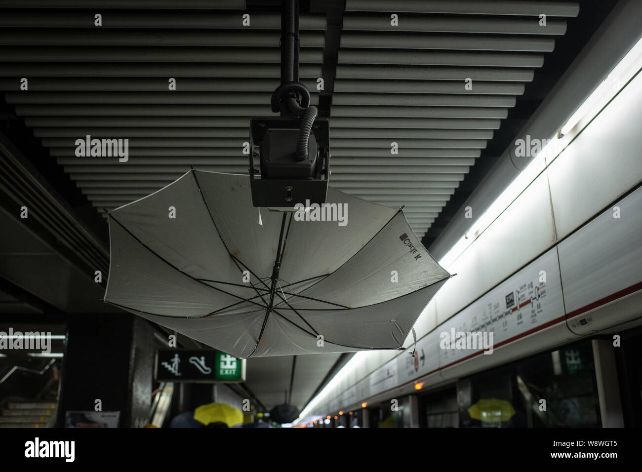 An umbrella blocks a surveillance camera at MTR Tsim Sha Tsui Station, during the demonstrations.Police agents and protesters clash in Nathan Road, Tsim Sha Tsui. A total of 35 people were arrested when Protesters took to the street to demonstrate against the government, they demand the complete withdraw of the extradition bill, and for the government to set up an independent inquiry into the recent clashes between protester and police. Police fired tear gas in response to another weekend of protests. Stock Photo