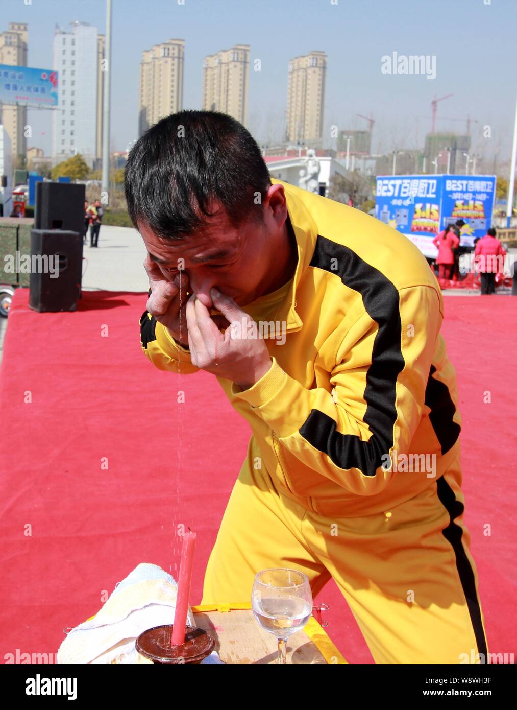 Zhang Yilong, a Chinese stunt performer dressed as Hong Kong action film star Bruce Lee, squirts water out of his right eye to put out a candle during Stock Photo