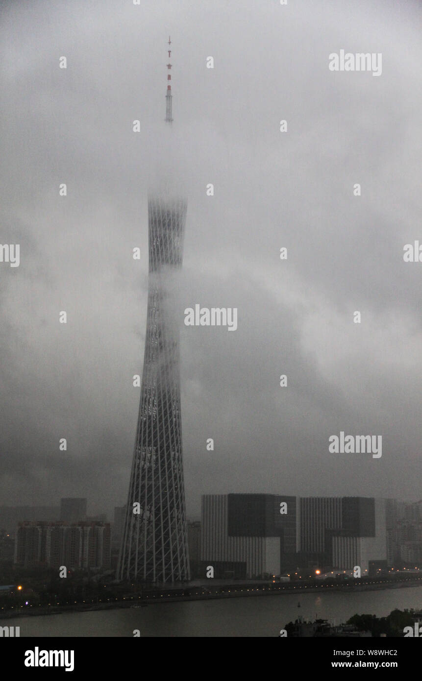 Heavy clouds of rainstorms shroud the Canton Tower and cover other buildings in Guangzhou city, south Chinas Guangdong province, 30 March 2014.   Heav Stock Photo