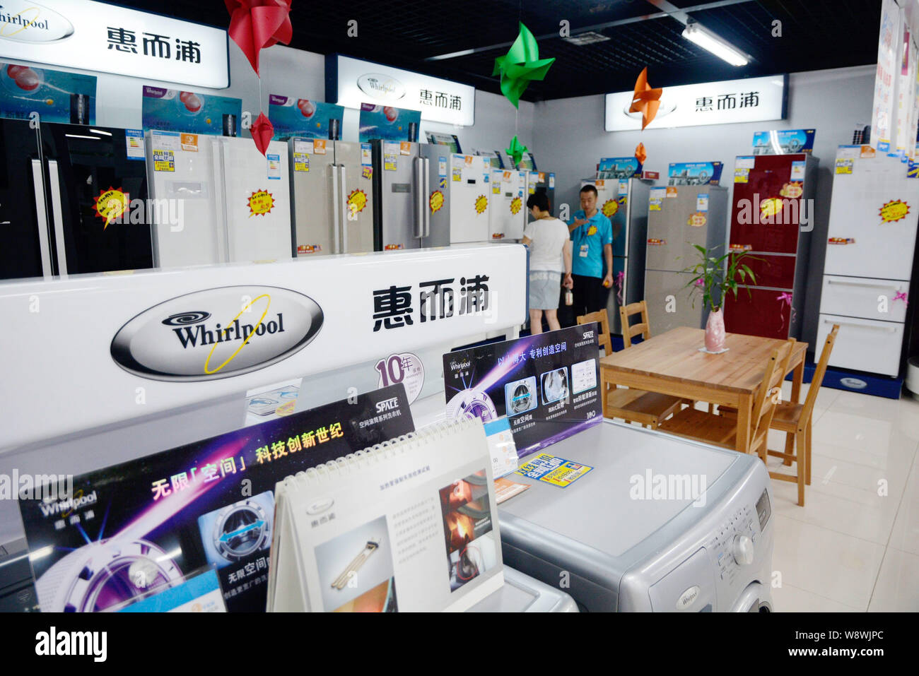 --FILE--A customer looks at Whirlpool refrigerators at a home appliances store in Dalian city, northeast Chinas Liaoning province, 4 August 2013.   Wh Stock Photo