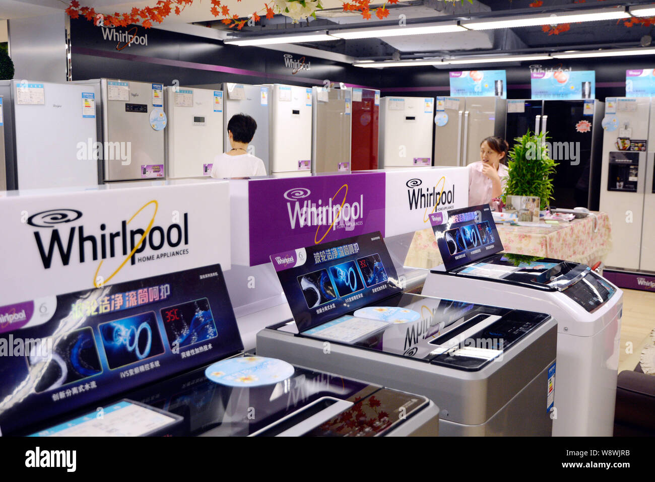 --FILE--A customer looks at Whirlpool refrigerators at a home appliances store in Dalian city, northeast Chinas Liaoning province, 4 August 2013.   Wh Stock Photo