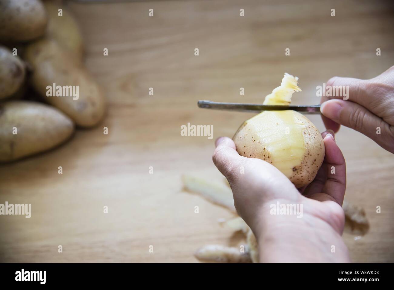 People cooking fresh potato preparing food in the kitchen - potato cooking concept Stock Photo