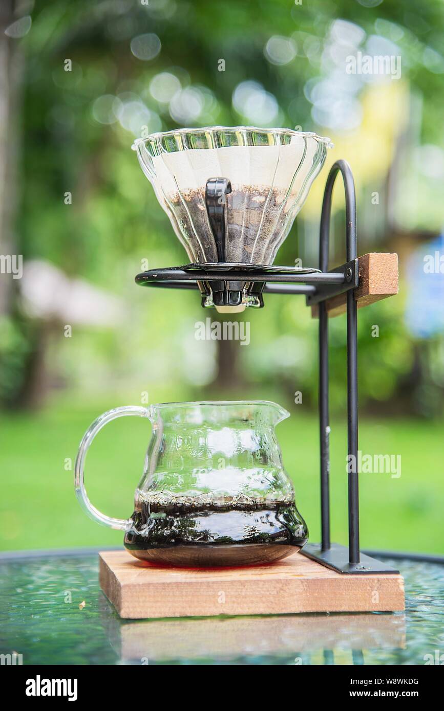 Making drip coffee in vintage coffee shop with green garden nature background - fresh coffee in nature concept Stock Photo