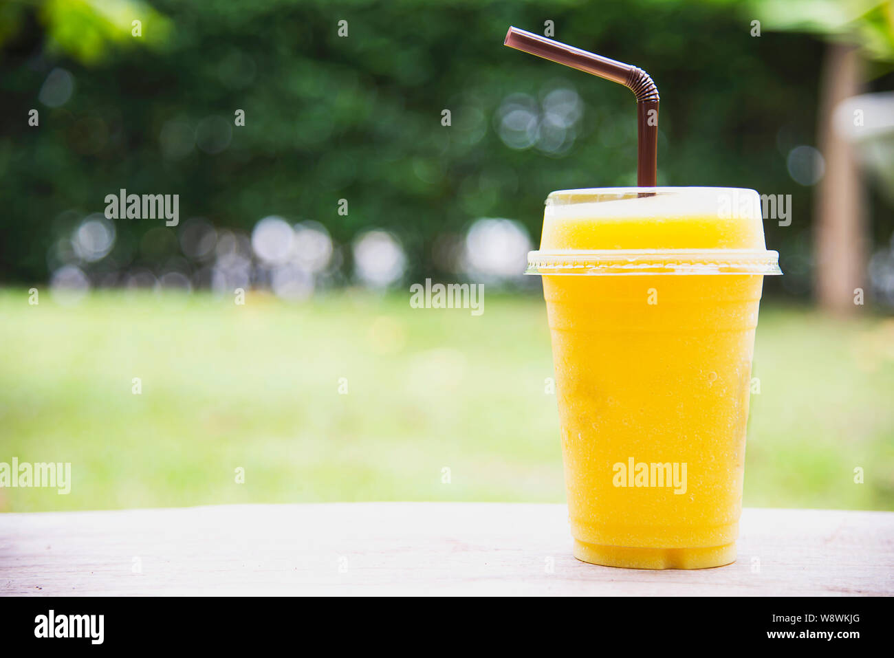 Ice mango orange blend in green garden - relax with cold fruit drink in nature concept Stock Photo
