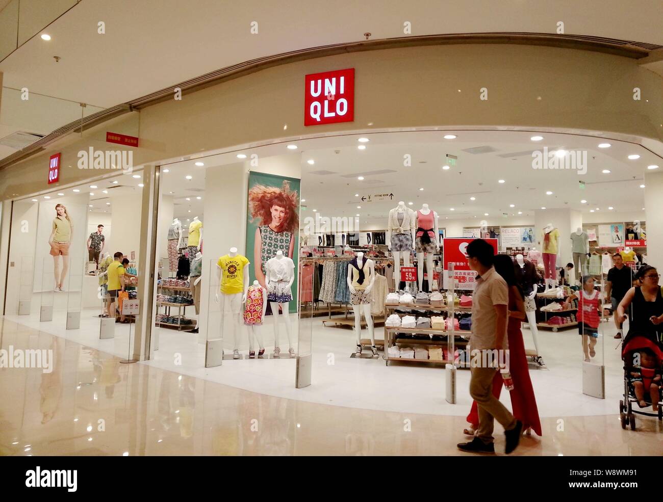 FILE--Pedestrians walk past a store of Uniqlo in Luoyang city, central  Chinas Henan province, 22 June 2014. Japan's Fast Retailing is expanding  Stock Photo - Alamy