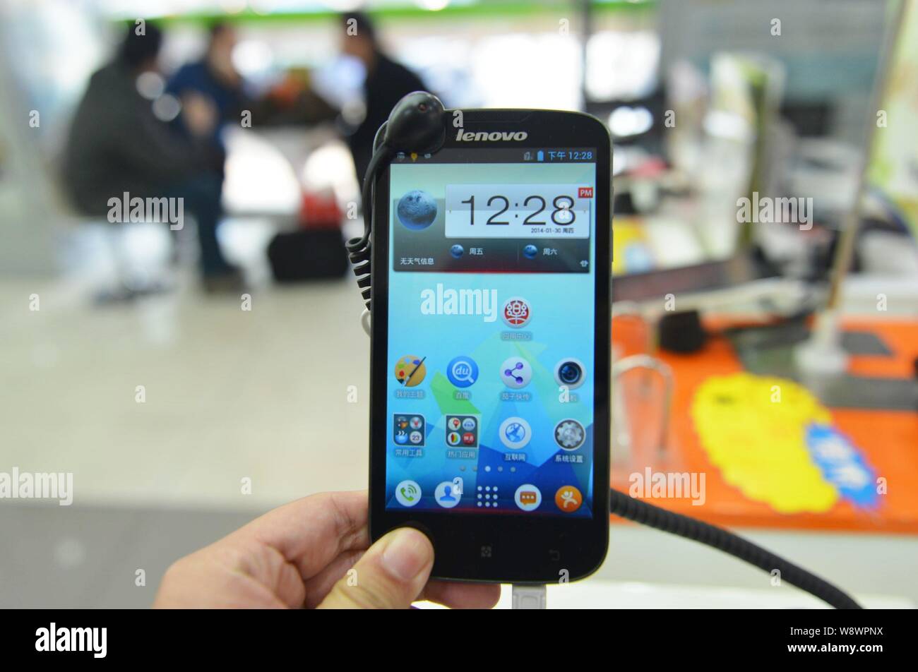 FILE--A customer tries out a Lenovo smartphone at a mobile phone store in  Hangzhou city, east Chinas Zhejiang province, 30 January 2014. Lenovo Gr  Stock Photo - Alamy