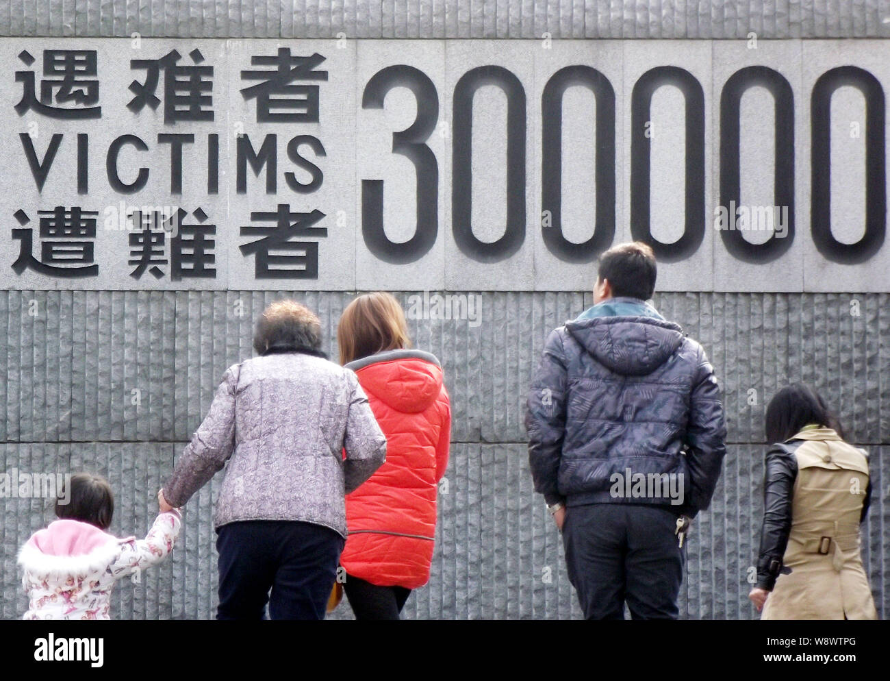 --FILE--Visitors walk past a sign showing the number of victims of the Nanjing Massacre at the Memorial Hall of the Victims in Nanjing Massacre by Jap Stock Photo