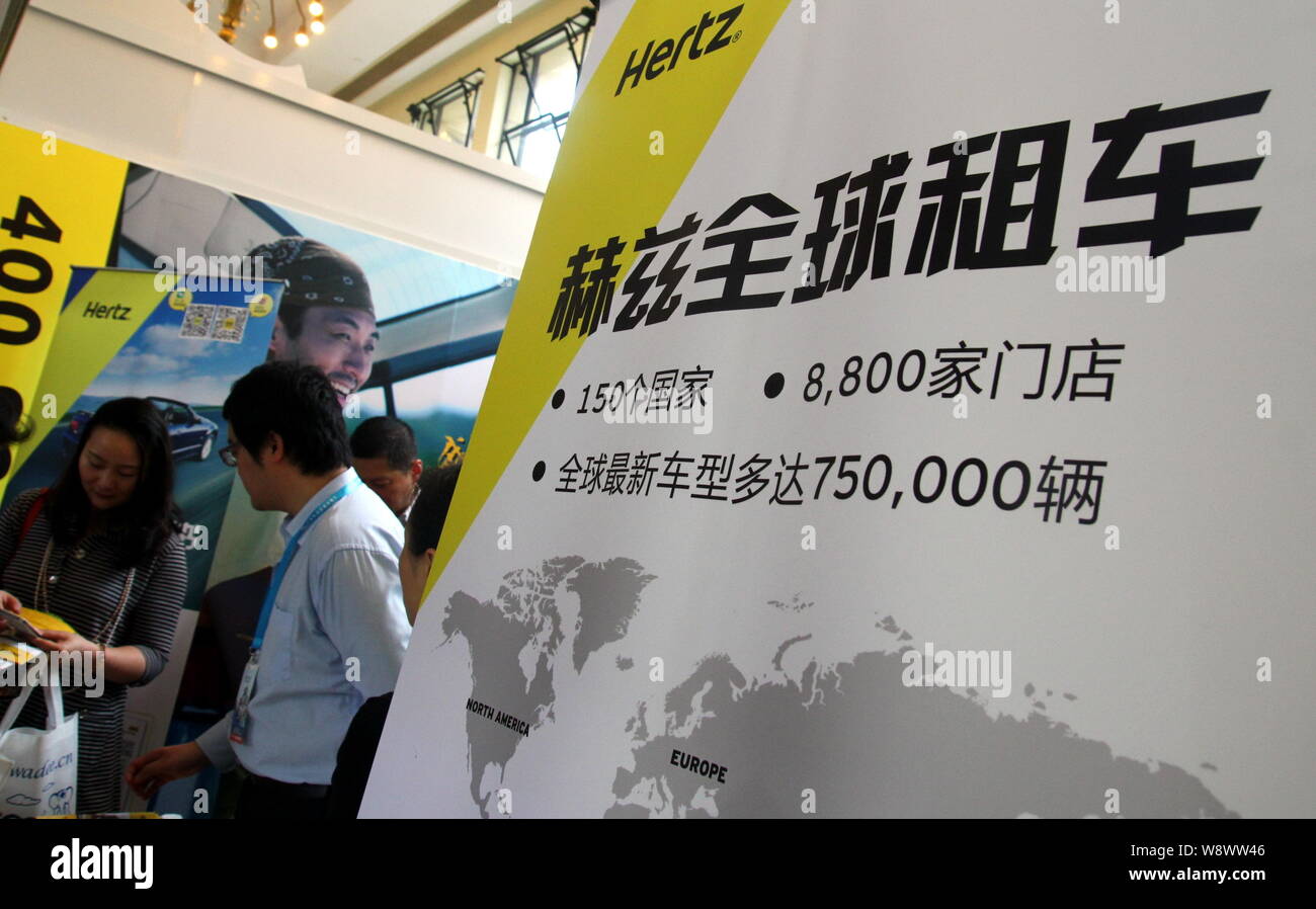 --FILE--Visitors walk past the stand of car rental company Hertz during an exhibition in Shanghai, China, 10 May 2014.   Chinese buy more cars than an Stock Photo