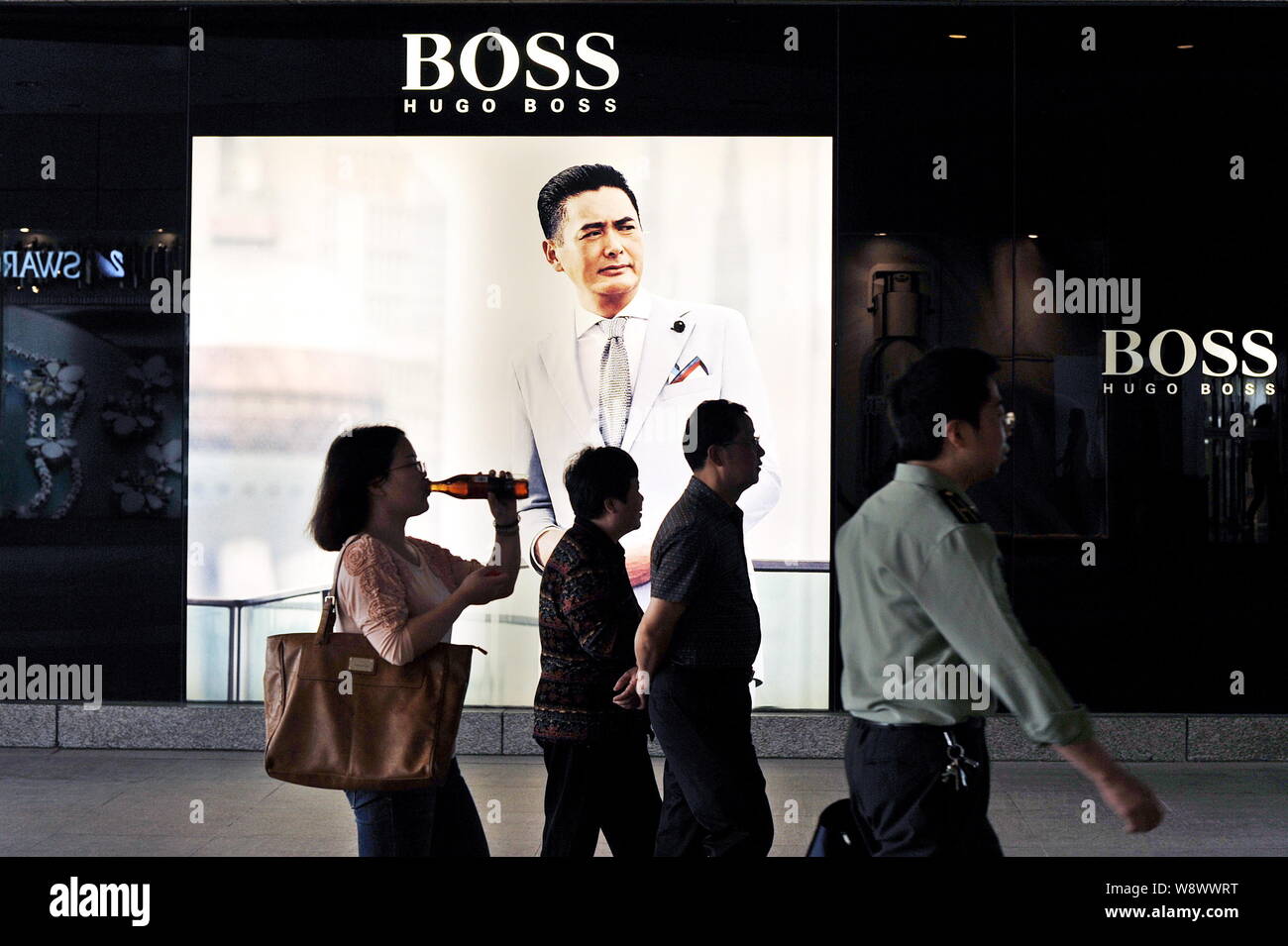 Proportioneel geloof Portaal FILE--Pedestrians walk past an advertisement of Hugo Boss at the Wuhan  International Plaza shopping mall in Wuhan city, central Chinas Hubei  provinc Stock Photo - Alamy