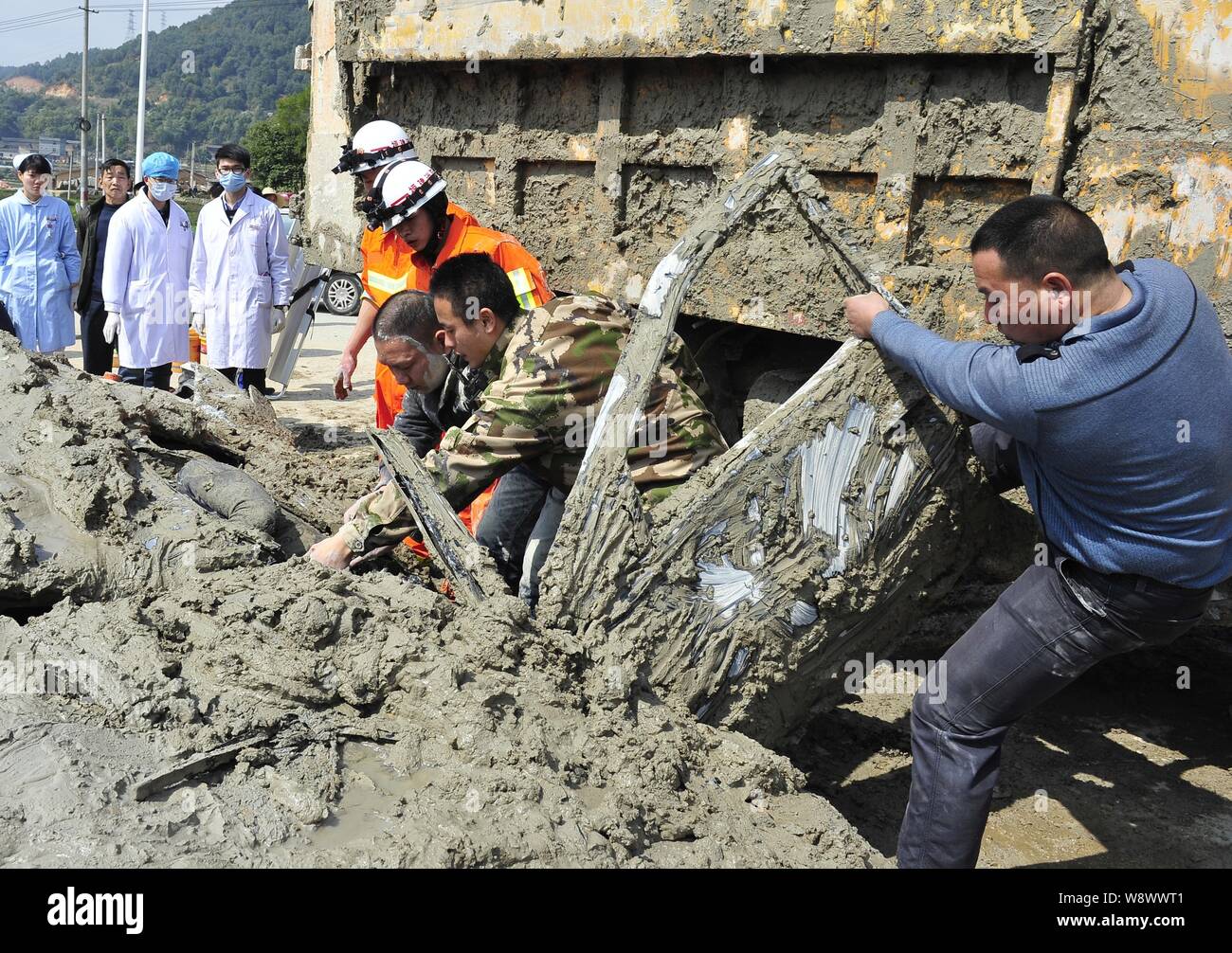 Rescue crew members try to pull out a female driver out of the car