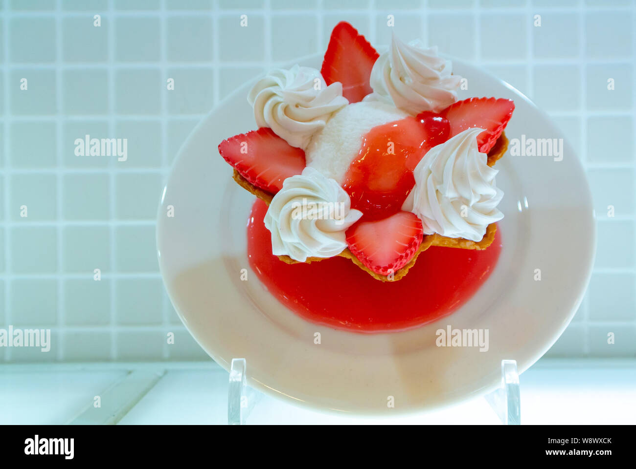 A sample of vanilla ice cream with strawberries and whip on a white dish, Japan Stock Photo