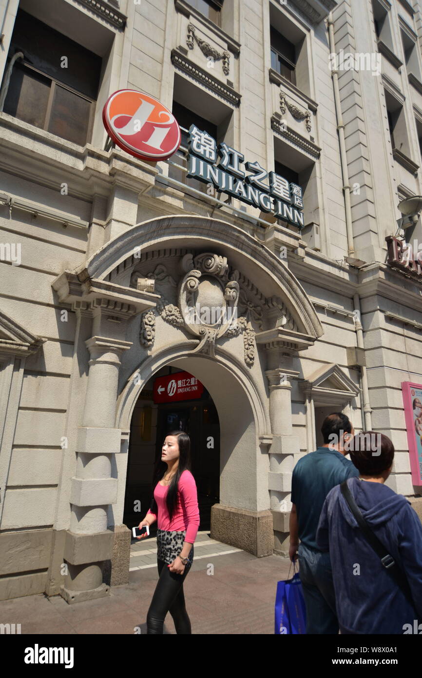 --FILE--Pedestrians walk past a Jin Jiang Inn of Shanghai Jin Jiang International Holdings Co. Ltd. in Shanghai, China, 17 March 2014.      Shanghai J Stock Photo