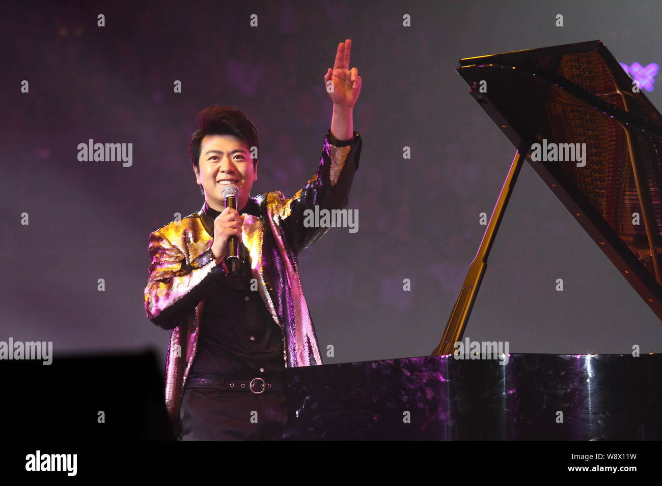 Chinese pianist Lang Lang greets the audience during a stars concert to celebrate the 60th birthday of Hong Kong actor Jackie Chan in Beijing, China, Stock Photo