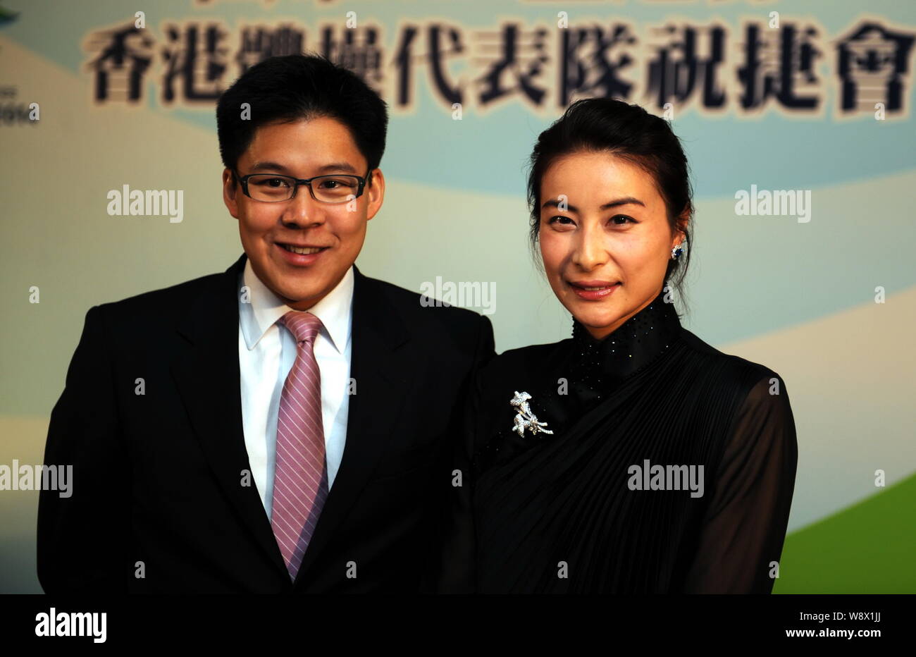 Kenneth Fok Kai-kong, eldest son of Hong Kong tycoon Timothy Fok Tsun-Ting, left, and his wife, Chinese Olympic diving champion Guo Jingjing, smile at Stock Photo