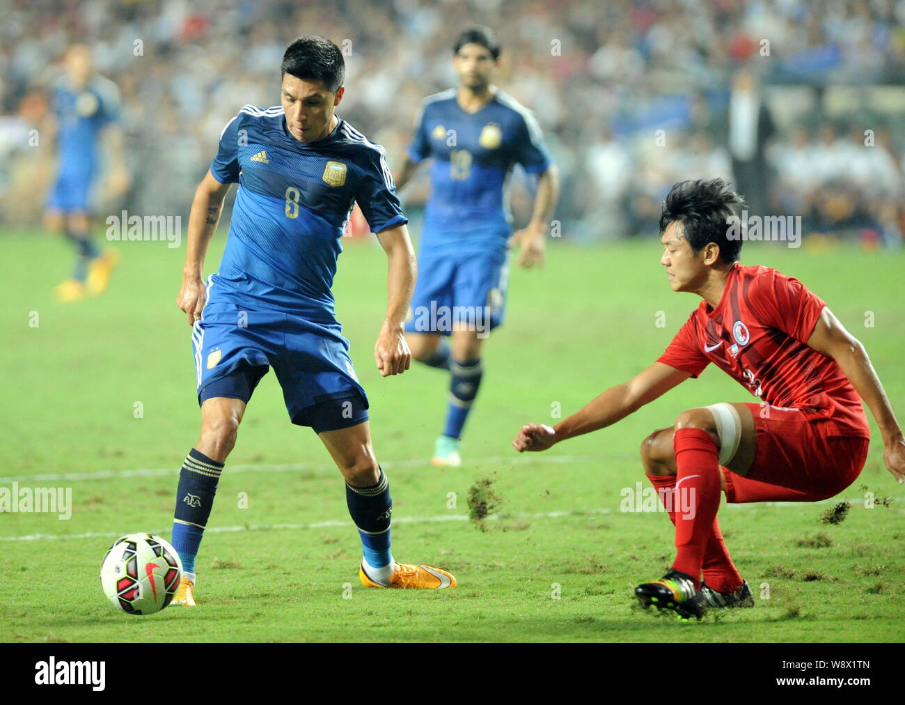 Enzo Perez of Argentina, left, challenges Cheung Kin-fung of Hong Kong during a friendly football match in Hong Kong, China, 14 October 2014.   Lionel Stock Photo