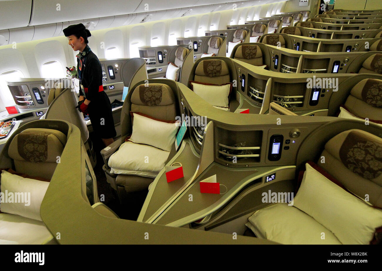 A flight attendant poses in a businessclass cabin of a Boeing 777300ER jet plane of China