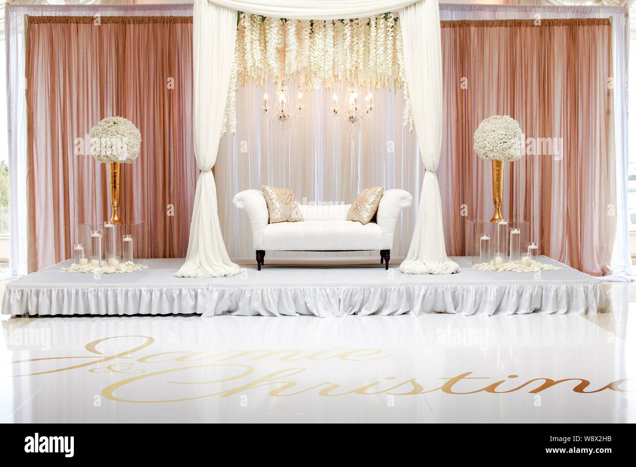 Beautiful Shot Of White Fabric Loveseat With Two Flower Centerpieces on