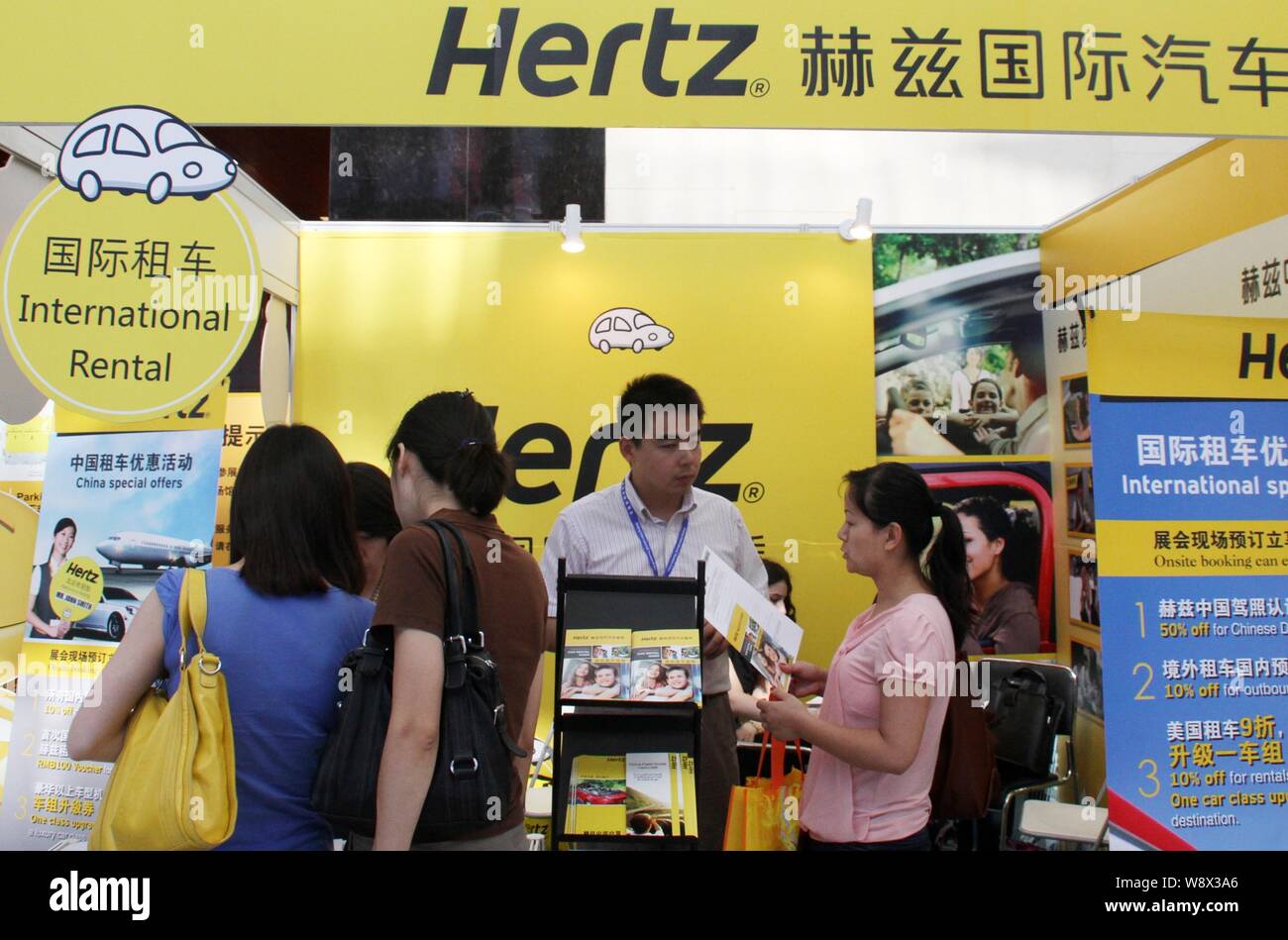 --FILE--People visit the stand of car rental company Hertz during an exhibition in Beijing, China, 17 June 2011.   Chinese buy more cars than anybody Stock Photo