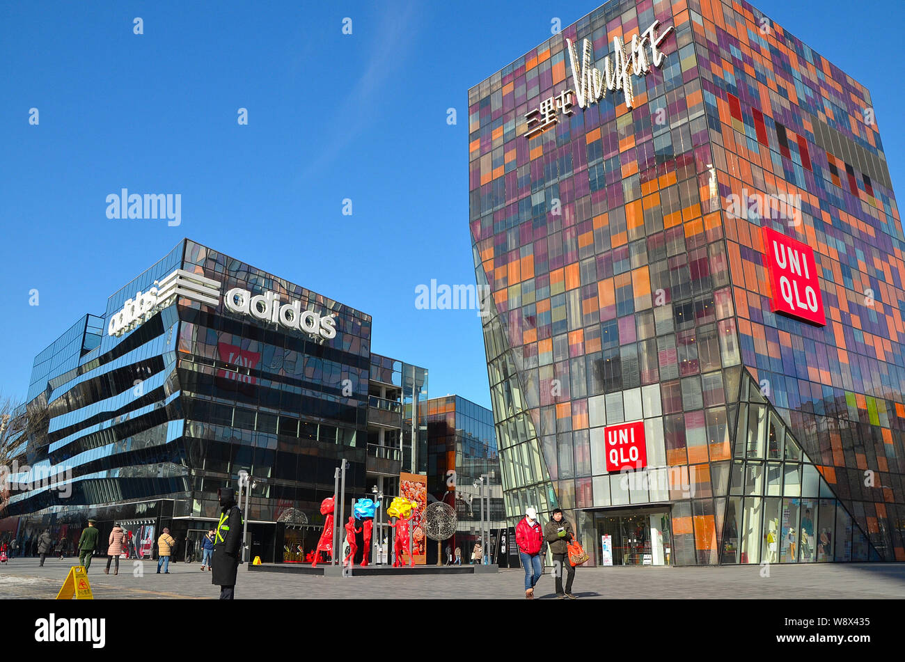 FILE--Pedestrians walk an Adidas sportswear store a Uniqlo store in Sanlitun Village, Beijing, China, 4 February 2013. The first Adidas n Stock Photo - Alamy