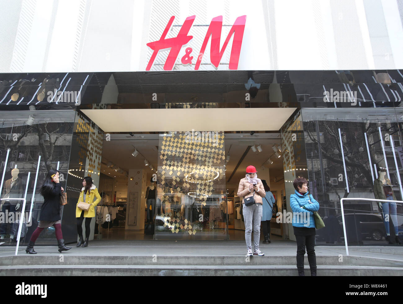 FILE--Pedestrians walk past a store of H&M in Shanghai, China, 13 March  2014. Multinational casual wear brands Meters/bonwe, Giordano, Esprit and  Stock Photo - Alamy