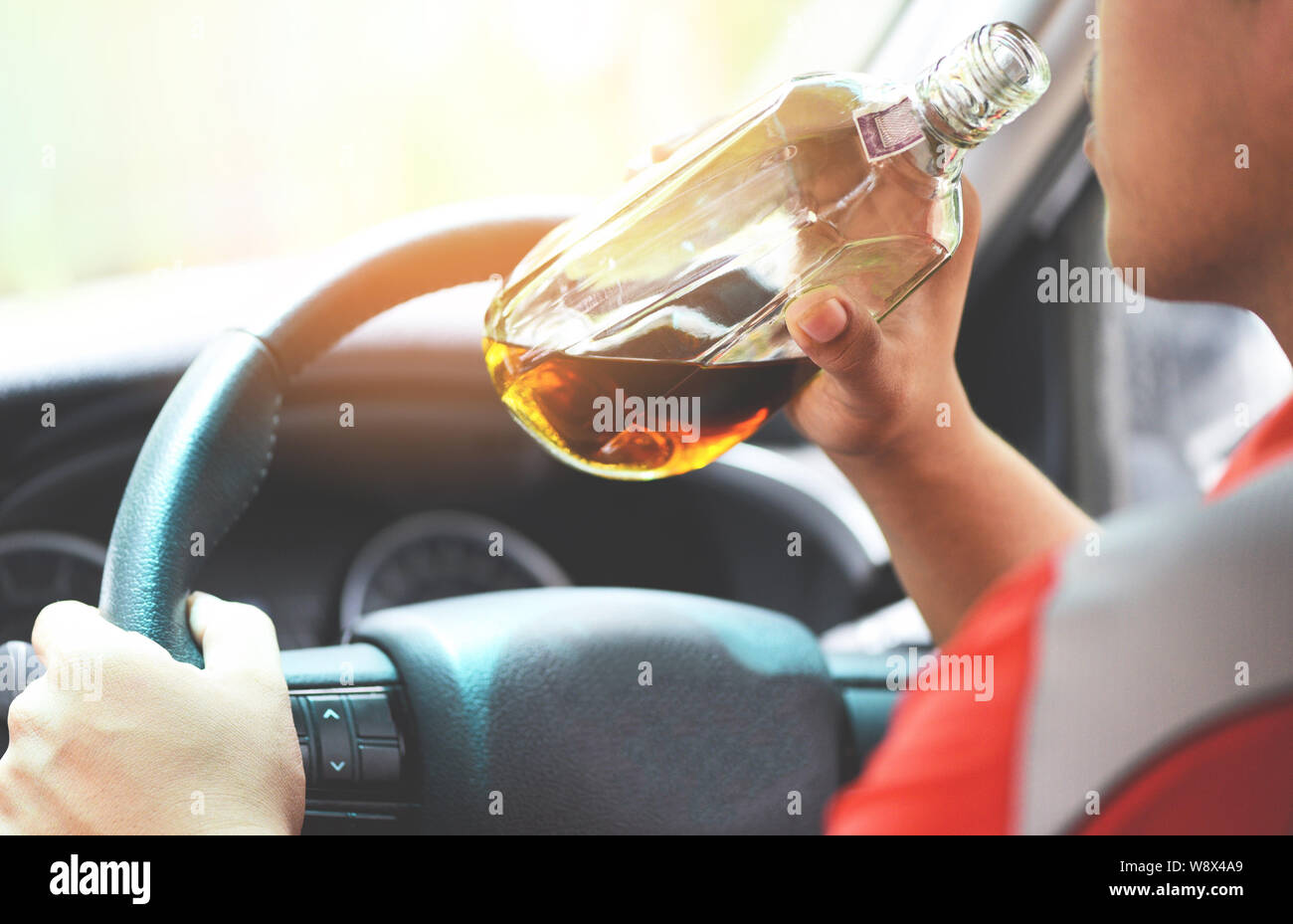 drunk driver concept / Man holding with alcohol bottle in hand and ...