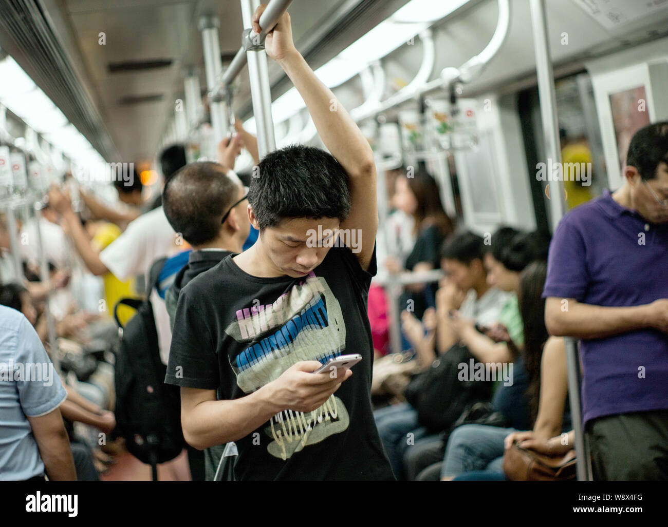 A passenger looks at his mobile phone in a subway train in Shanghai ...