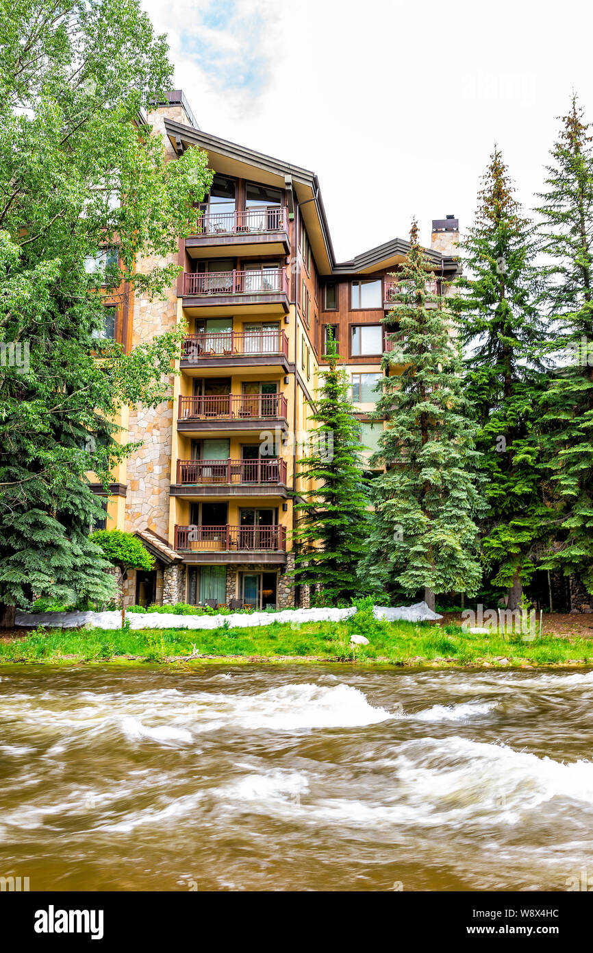 Vail, USA - June 29, 2019: European style town condominium building in Colorado by Gore creek river Stock Photo