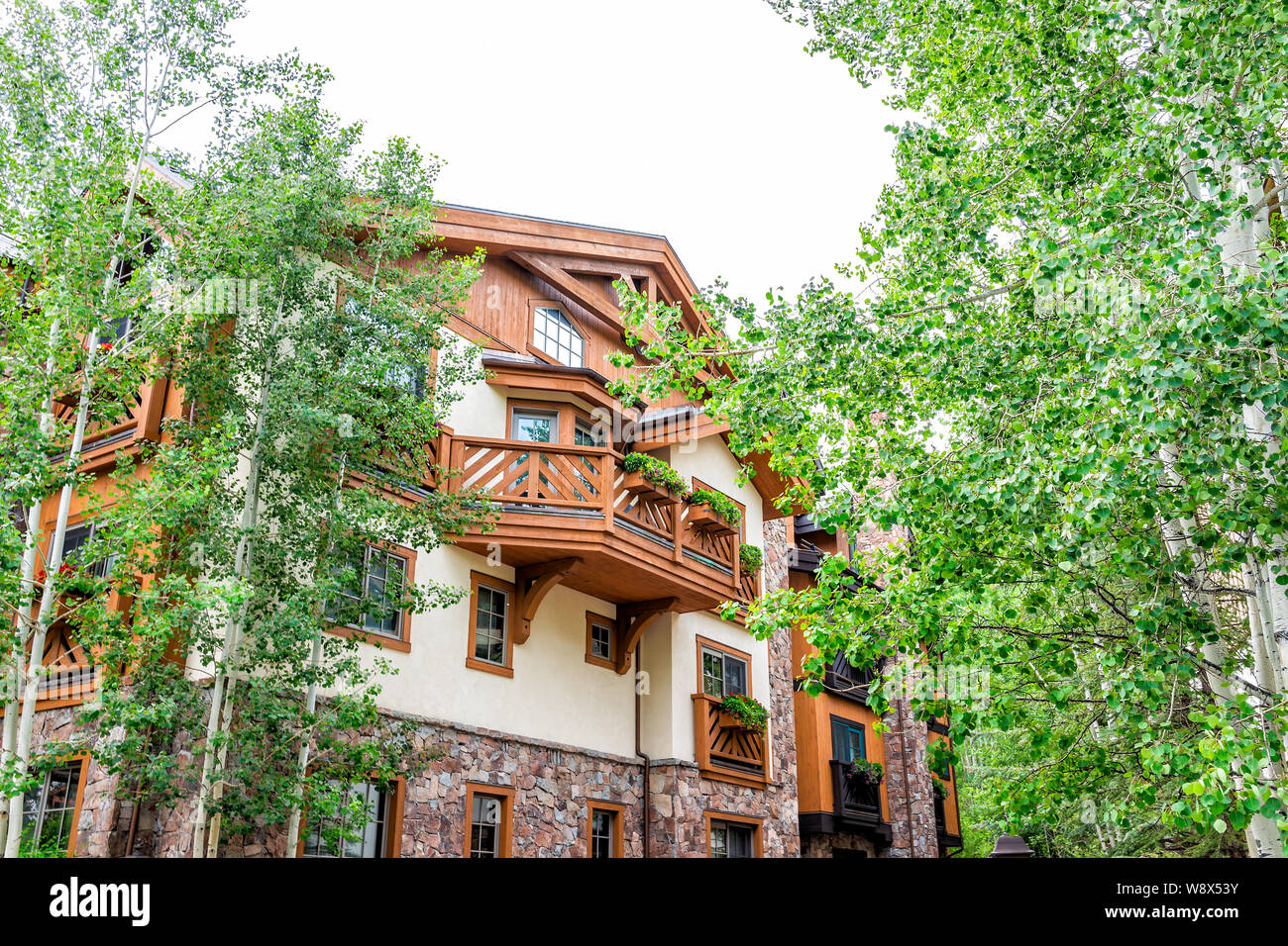 Vail, USA - June 29, 2019: European wooden style resort town condominium building in Colorado with green Aspen trees Stock Photo