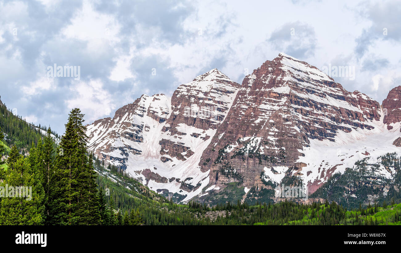 Maroon Bells closeup in Aspen, Colorado during blue hour cloudy dawn before sunrise with rocky mountain peak and snow in early summer Stock Photo