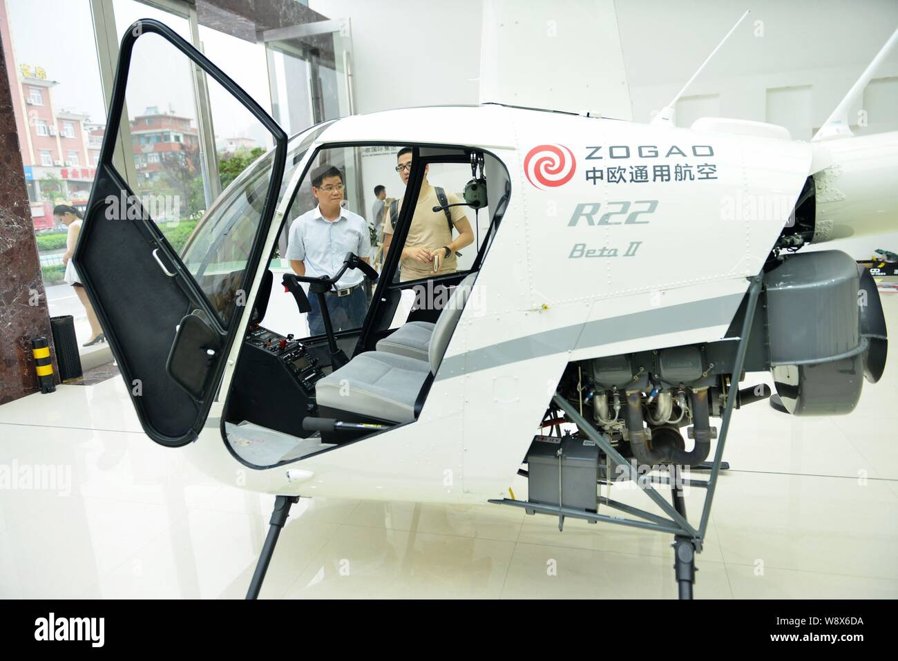 Local Residents Look At An R22 Beta O Helicopter Manufactured By Robinson Helicopter Co At A Car Dealership In Hangzhou City East Chinas Zhejiang Pr Stock Photo Alamy