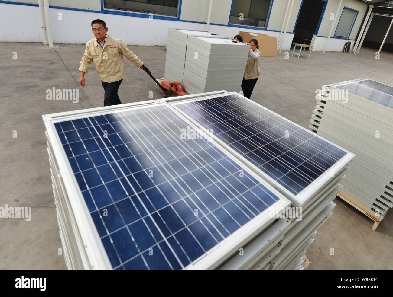 --FILE--Chinese workers cart solar panels at the plant of Shandong Hilight Solar Co., Ltd. in Zouping county, Binzhou city, east Chinas Shandong provi Stock Photo