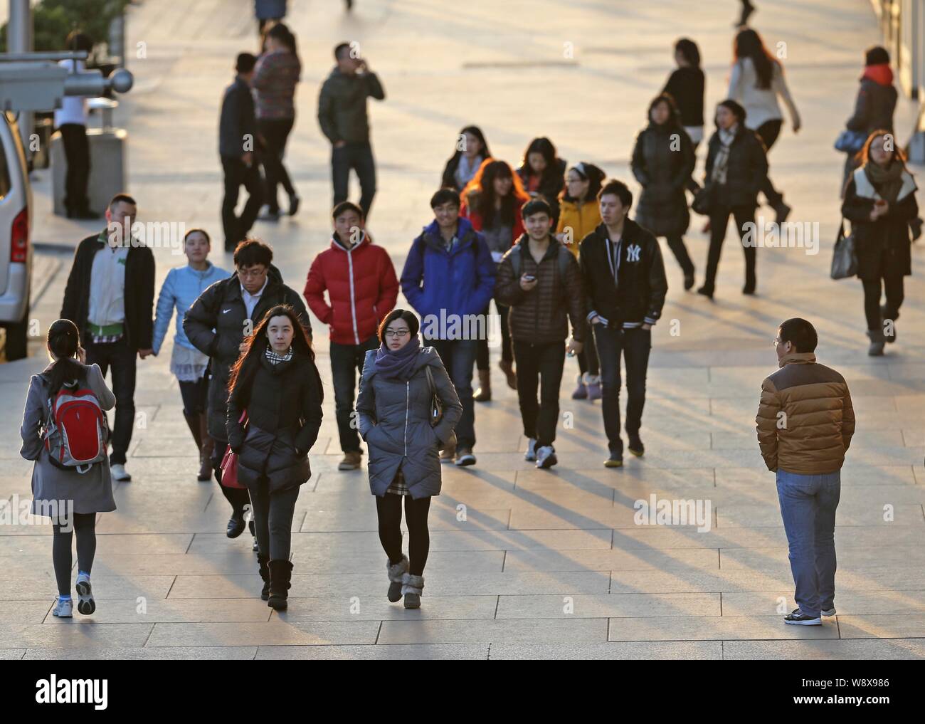 --FILE--Local residents walk on a road in Beijing, China, 27 February 2014.   China has issued a behavioural standards guide to combat pollution and r Stock Photo