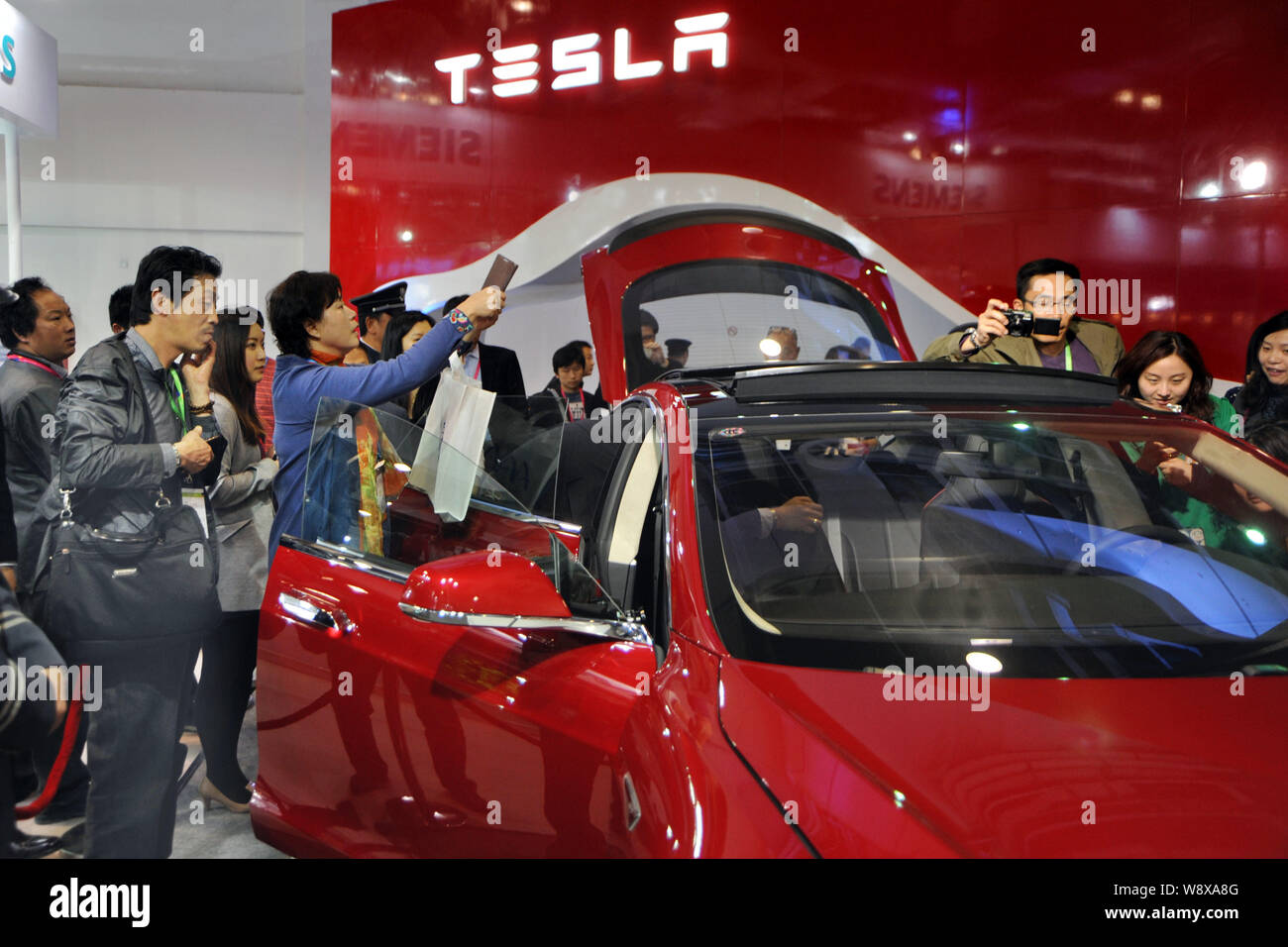 --FILE--Visitors look at a Tesla Model S electric car during the 2nd ...