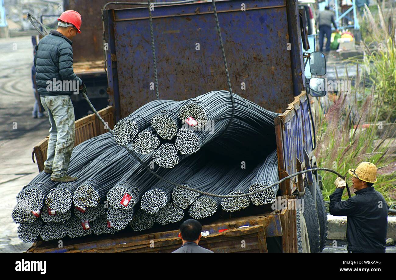 --FILE--Chinese workers unload reinforcing steel bars from a truck on a quay in Yichang city, central China's Hubei province, 5 November 2014.   China Stock Photo