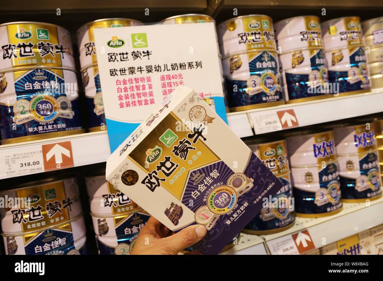 --FILE--A customer shops for a carton of Mengniu Arla milk powder at a supermarket in Xuchang city, central Chinas Henan province, 5 April 2014.   A r Stock Photo