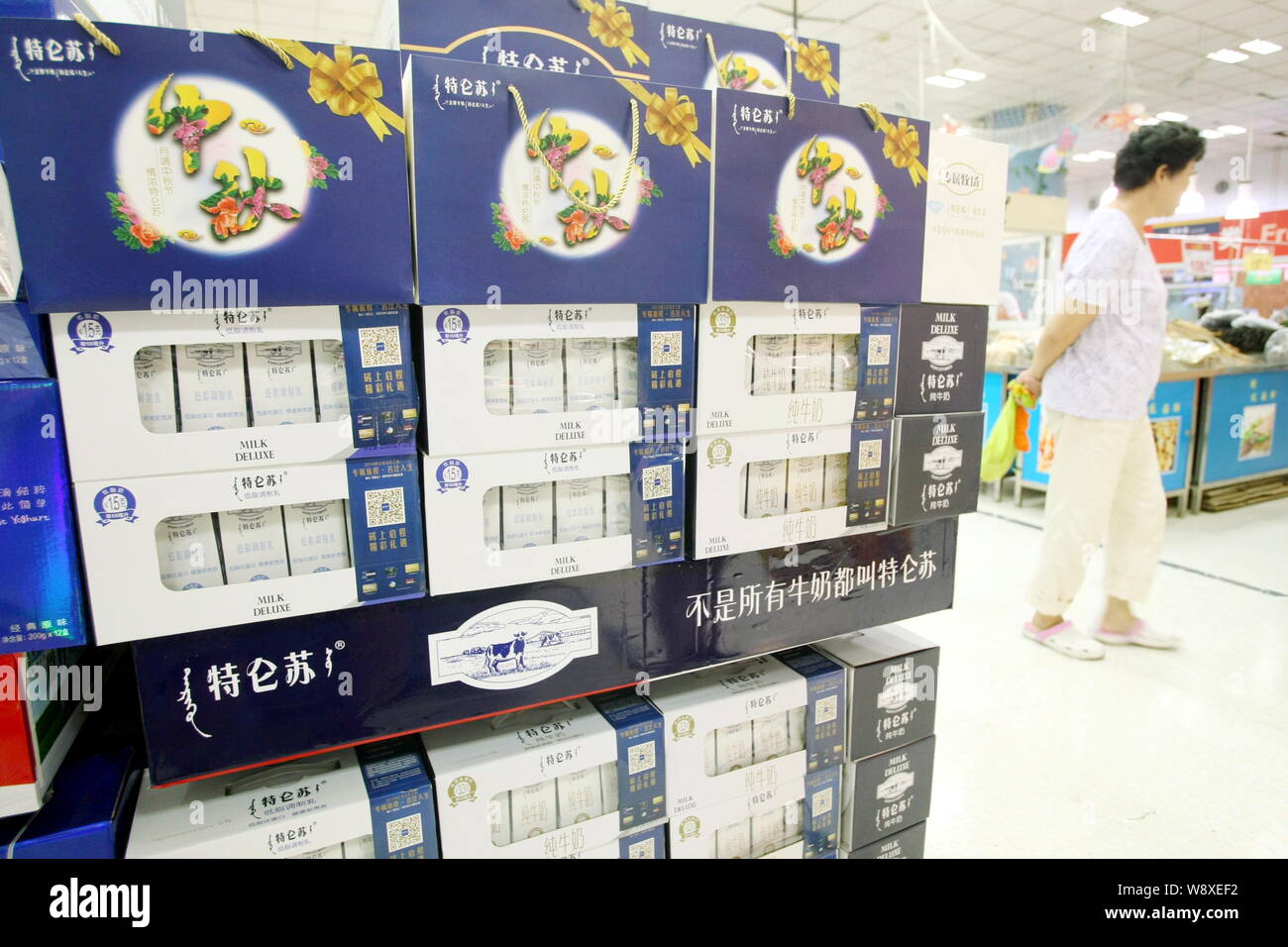 FILEA Chinese customer walks past cartons of Mengniu Milk Deluxe at