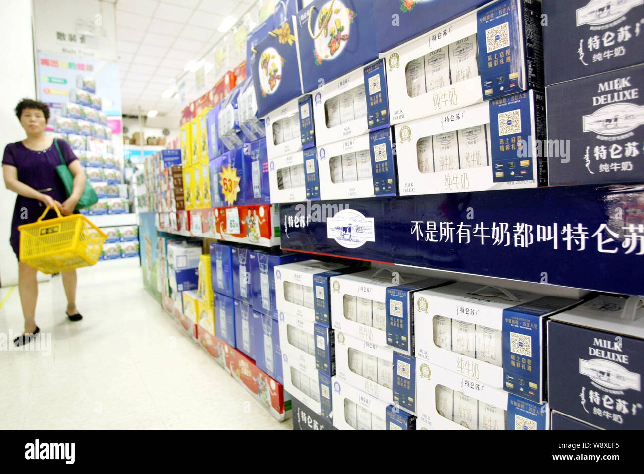 FILEA Chinese customer walks past cartons of Mengniu Milk Deluxe at