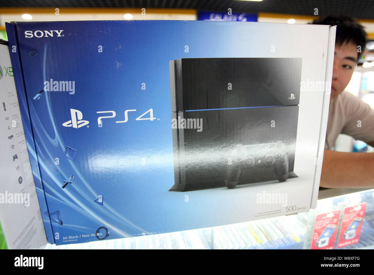 FILE--A Chinese vendor looks on next to a smuggled Sony PlayStation 4 (PS4)  game console for sale at a digital products mall in Shanghai, China, 29  Stock Photo - Alamy