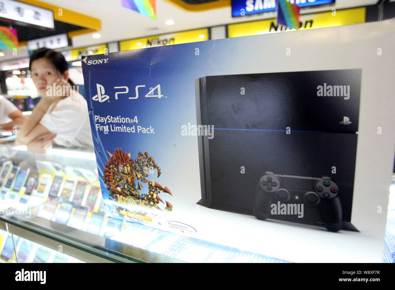 A Chinese vendor looks on next to a smuggled Sony PlayStation 4 (PS4) game  console for sale at a digital products mall in Shanghai, China, 29 May 2014  Stock Photo - Alamy