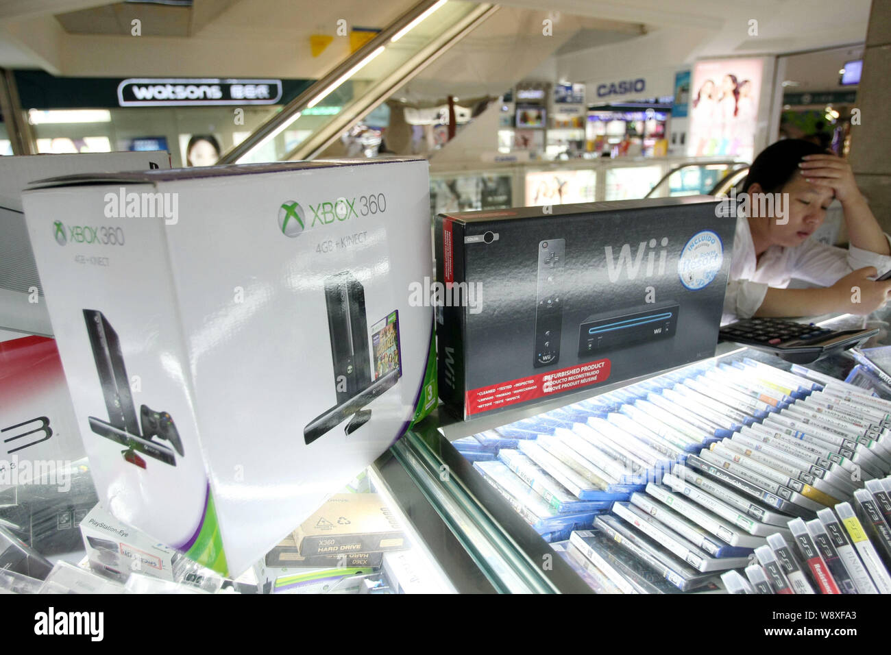 --FILE--Microsoft XBOX 360 and Nintendo Wii game consoles are for sale at a stall in a digital products mall in Shanghai, China, 29 May 2014.    JD.co Stock Photo