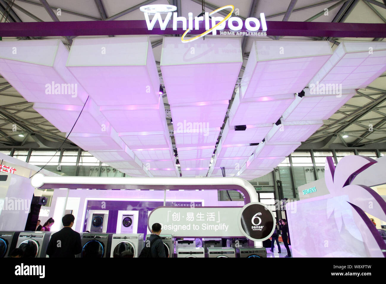 --FILE--Visitors look at Whirlpool washing machines during an exhibition in Shanghai, China, 23 March 2014.   Whirlpool Corp. managed to break its sal Stock Photo