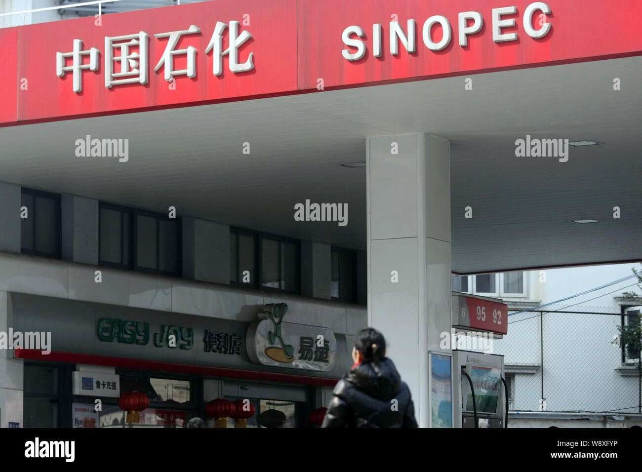 A pedestrian walks past a gas station of Sinopec in Shanghai, China, 20 February 2014.   Sinopec Corp , Asias largest oil refiner, plans to sell up to Stock Photo