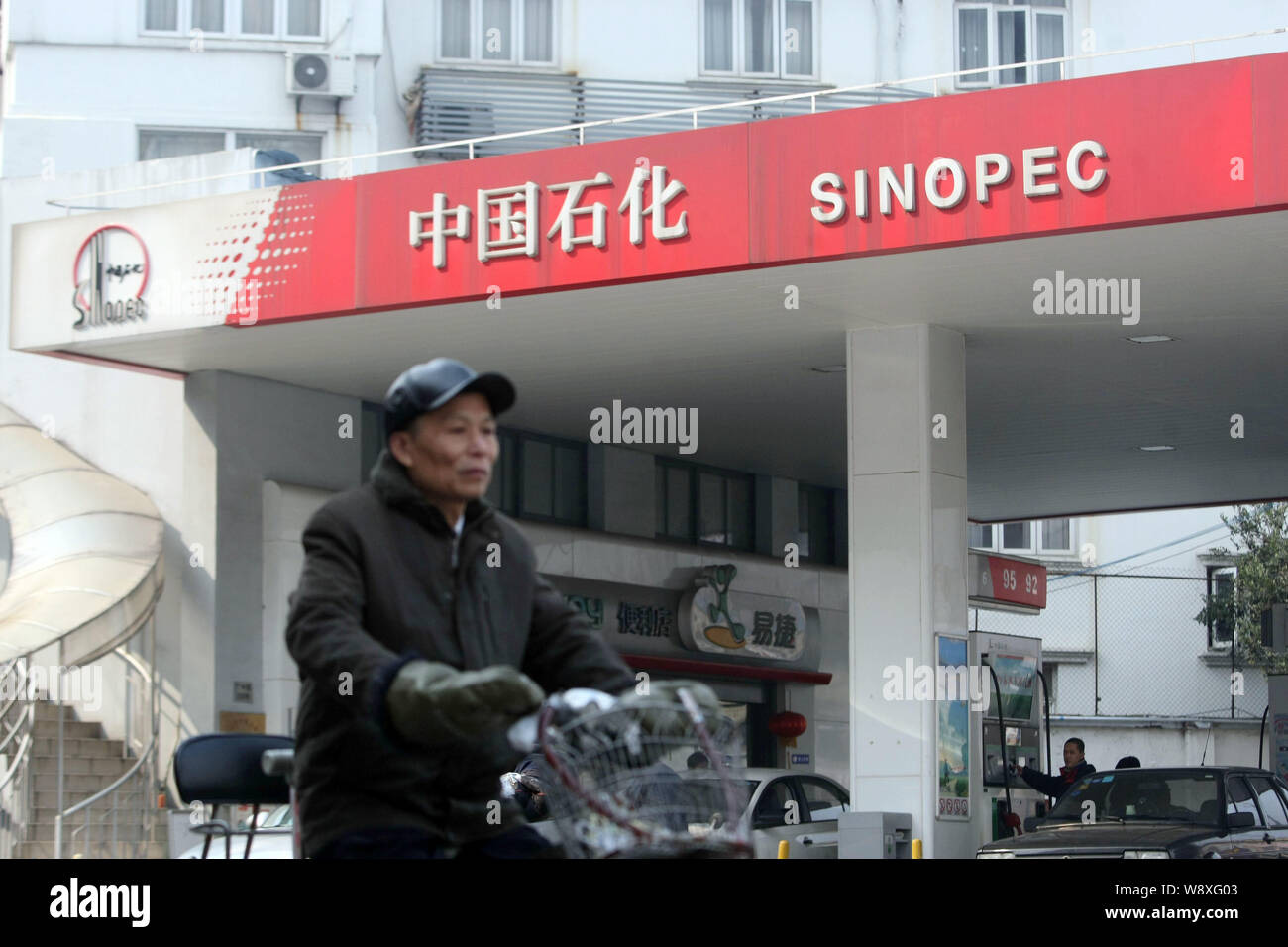 A cyclist rides past a gas station of Sinopec in Shanghai, China, 20 February 2014.   Sinopec Corp , Asias largest oil refiner, plans to sell up to 30 Stock Photo