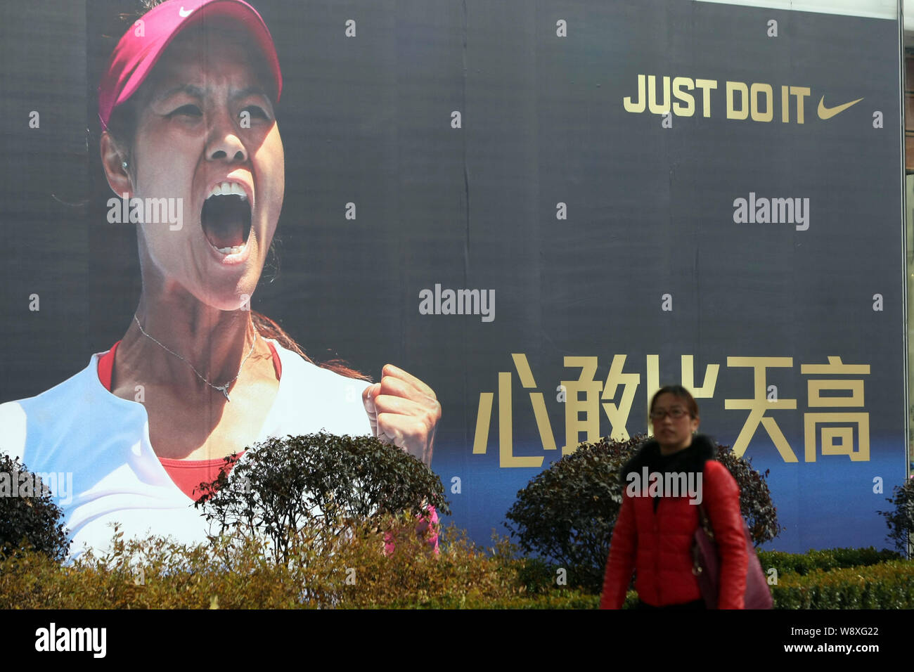 A pedestrian walks past an advertisement of Nike with the portrait of  Chinese tennis star Li Na in Shanghai, China, 26 January 2014. Li Na is  confid Stock Photo - Alamy