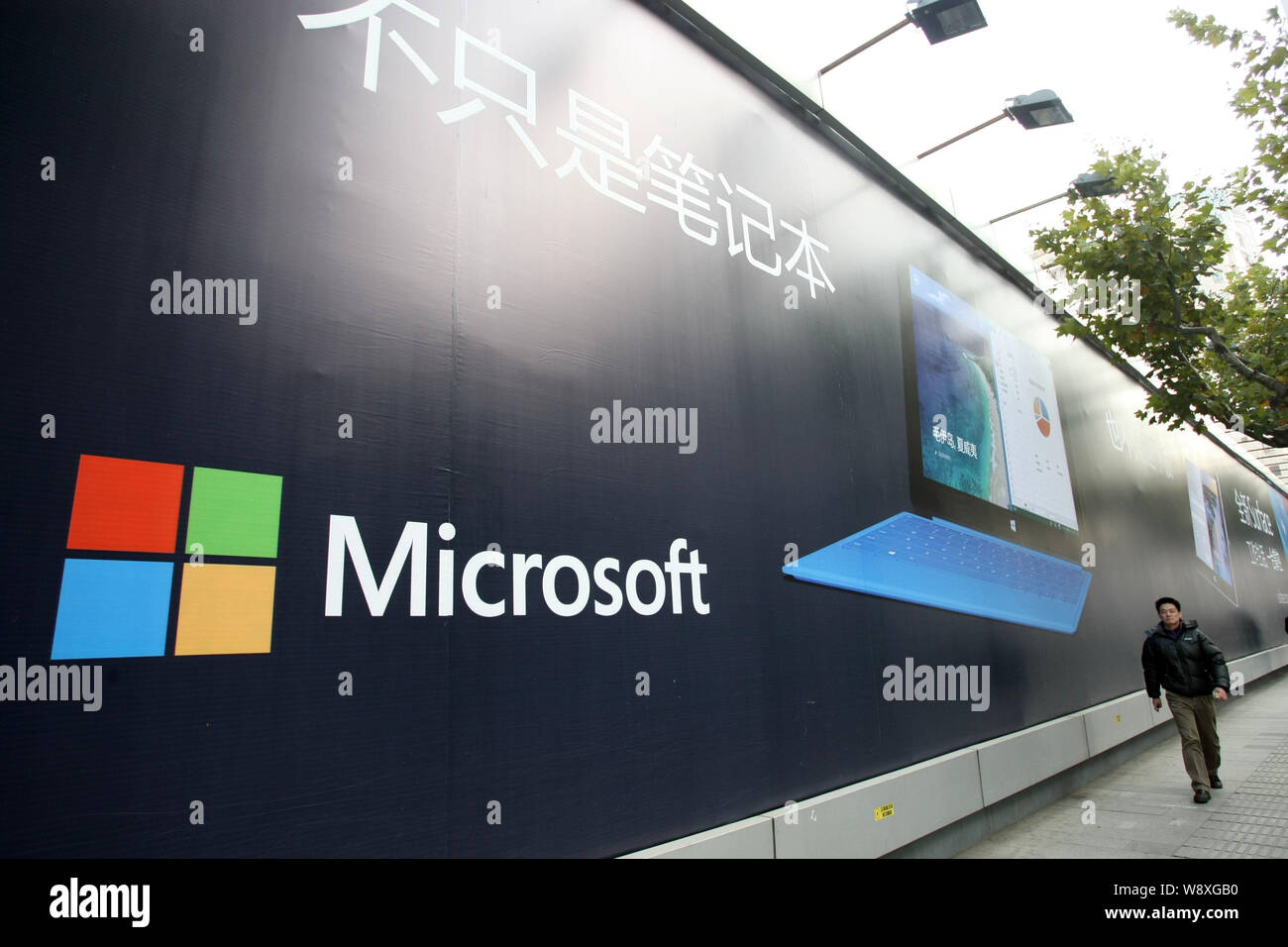 --FILE--A pedestrian walks past an advertisement for Microsoft Surface pro 2 in Shanghai, China, 12 December 2013.   Nokia Corp. said Tuesday (8 April Stock Photo