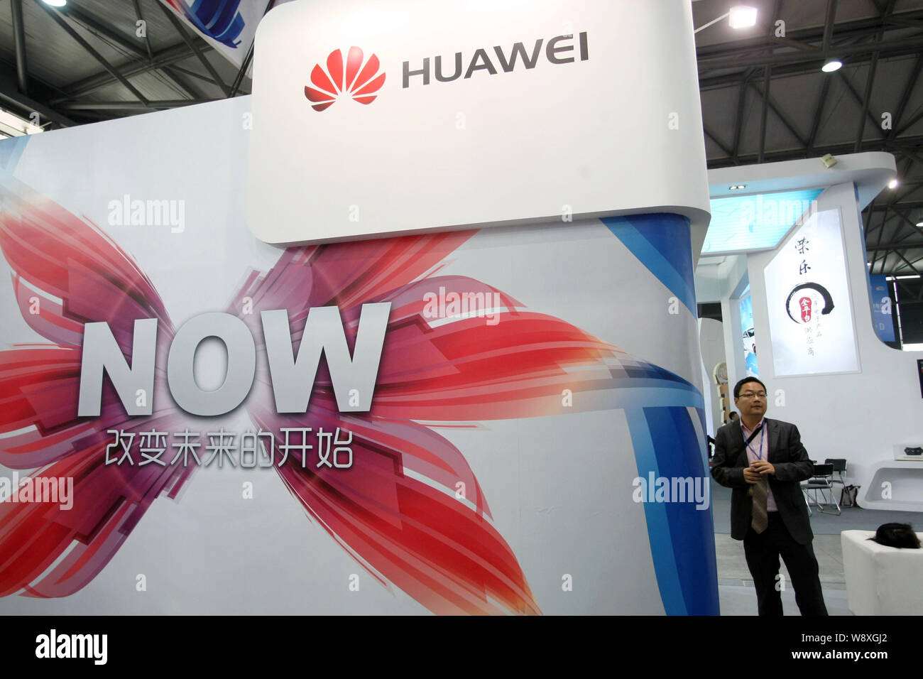 A man visits the stand of Huawei at an exhibition in Shanghai, China, 21 January 2014.   Facing new efforts by a hostile Obama administration to shut Stock Photo