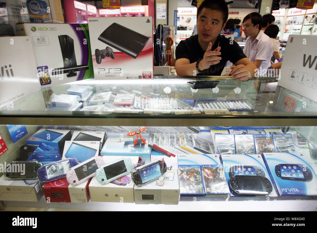 FILE--A salesman sells Sony PS3, PSVita, PSP, Microsoft XBOX 360, Nintendo  Wii and 3DS game consoles at a stall in a digital products mall in Shangh  Stock Photo - Alamy